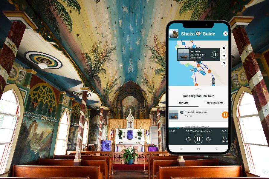 Smartphone displaying the Shaka Guide app inside a painted historic church with wooden pews, colorful murals, and a vaulted ceiling.