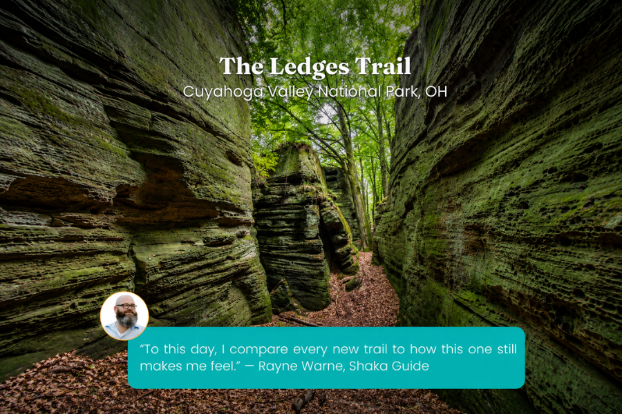 A narrow trail winds through towering moss-covered sandstone cliffs in a peaceful forest setting. The image includes a traveler quote praising the trail's unforgettable atmosphere.