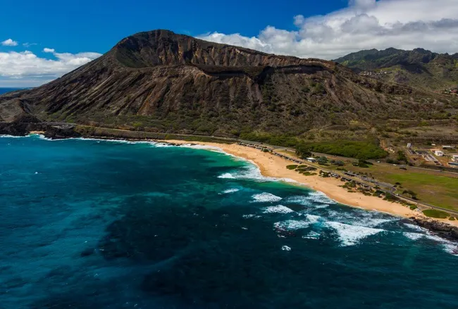 mountain with crater and sea below it