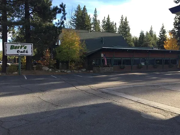 Bert's Cafe exterior with a sign, located in South Lake Tahoe, surrounded by trees and visible parking area.