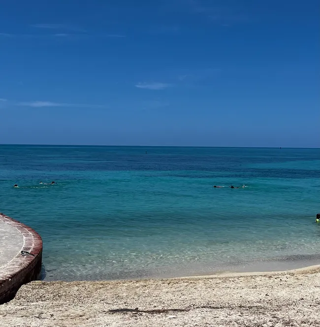 Swimmers enjoying the clear turquoise waters near the shore at Dry Tortugas National Park.