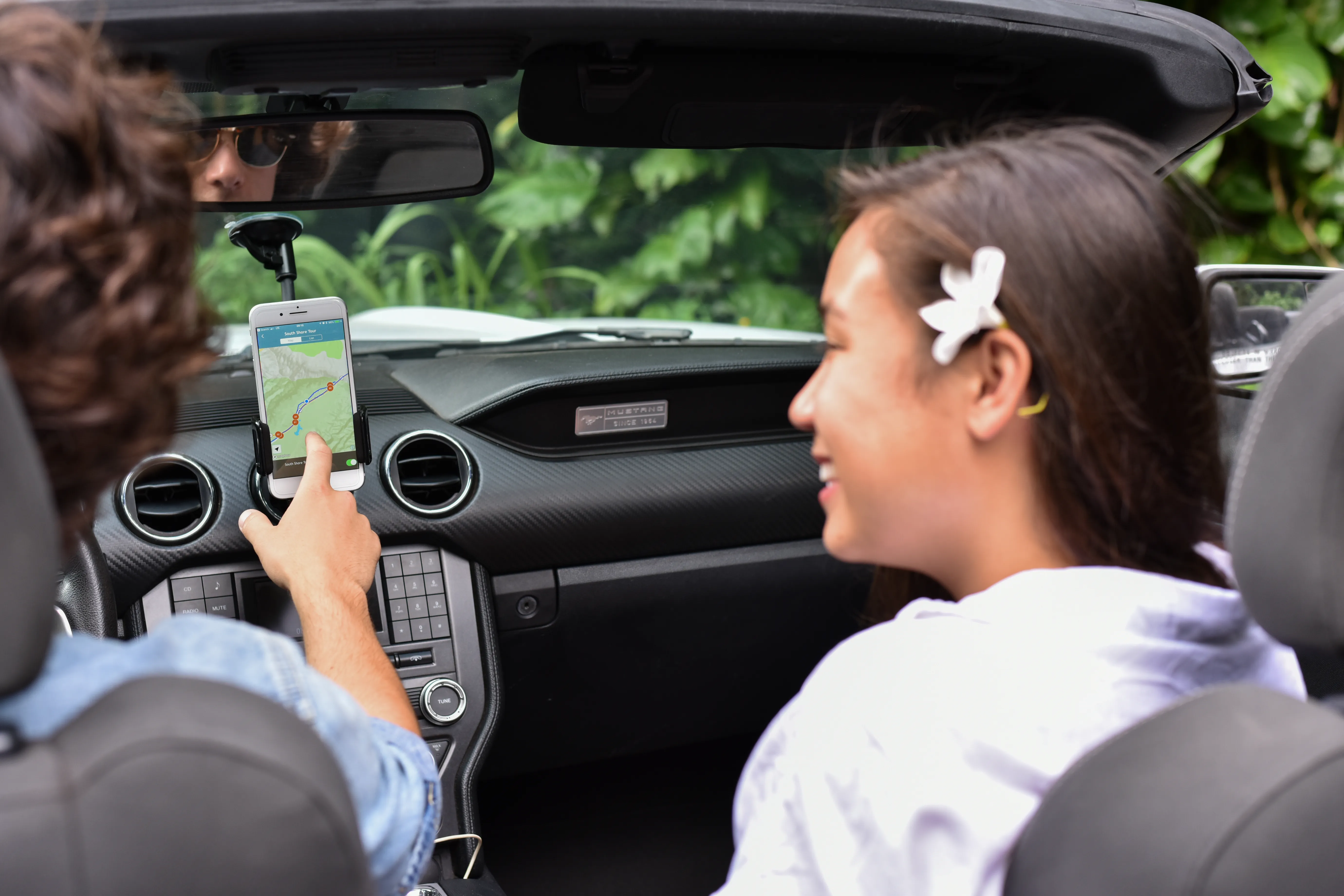 Close-up of phone using the Road to Hana tour, visible on screen in Mustang interior.