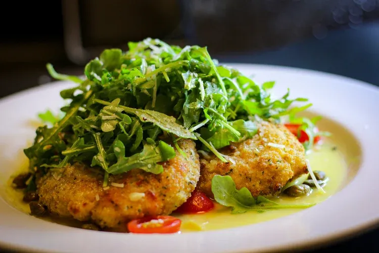 Crispy dishes topped with fresh arugula and tomatoes served at Pueo’s Osteria in Waikoloa.