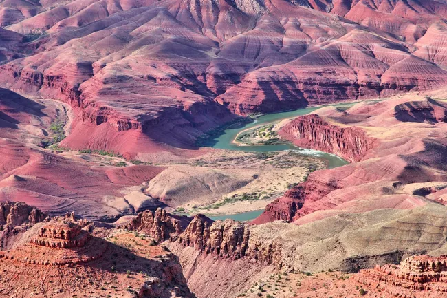 Colorful layered cliffs and a winding section of the Colorado River viewed from Lipan Point on the South Rim.