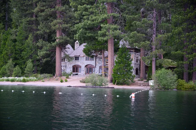 Stone Vikingsholm mansion nestled among tall pine trees on the shore of Emerald Bay, Lake Tahoe.