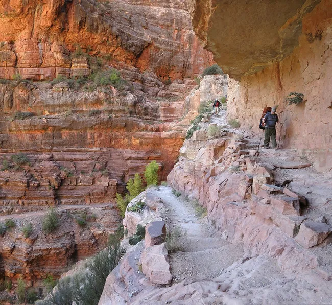 hiker hiking the edge of a cliff