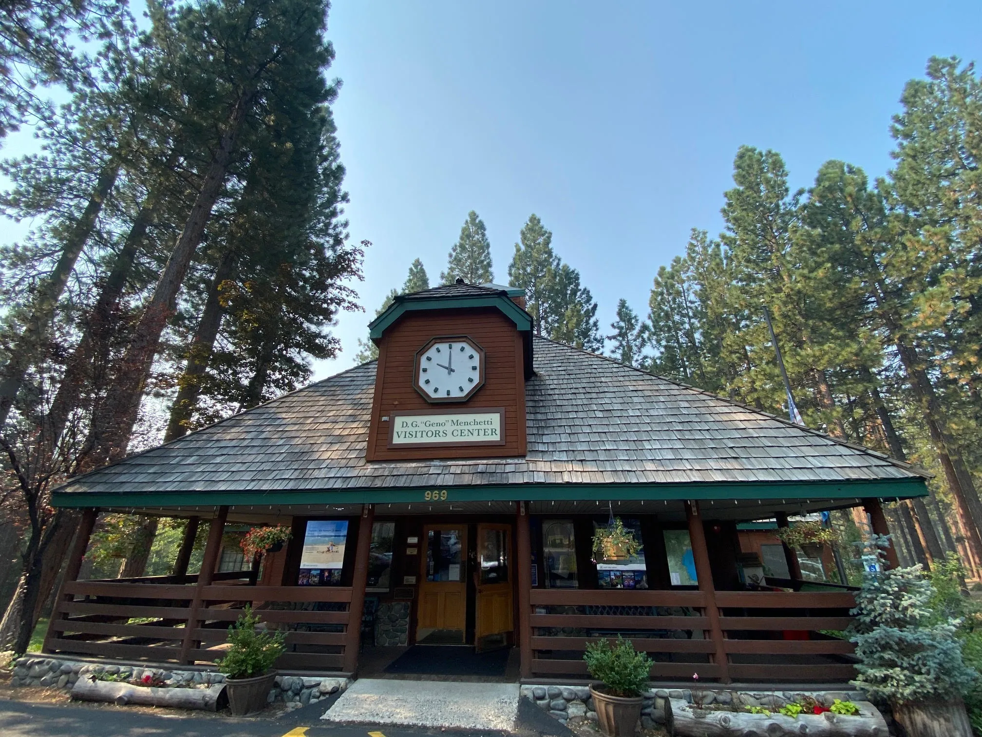 Incline Village Visitor Center building with clock tower surrounded by tall pine trees at Lake Tahoe.