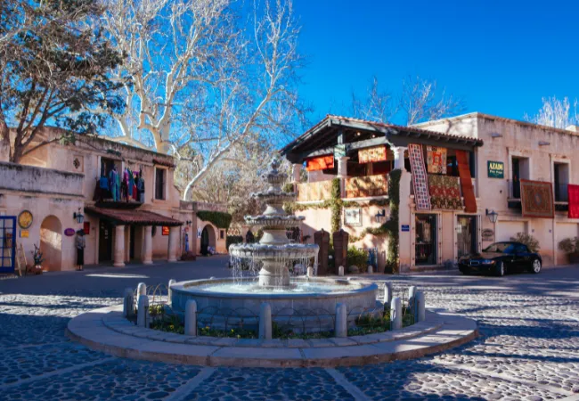 A charming fountain sits at the center of Tlaquepaque Arts Village, surrounded by shops and cobblestone paths.