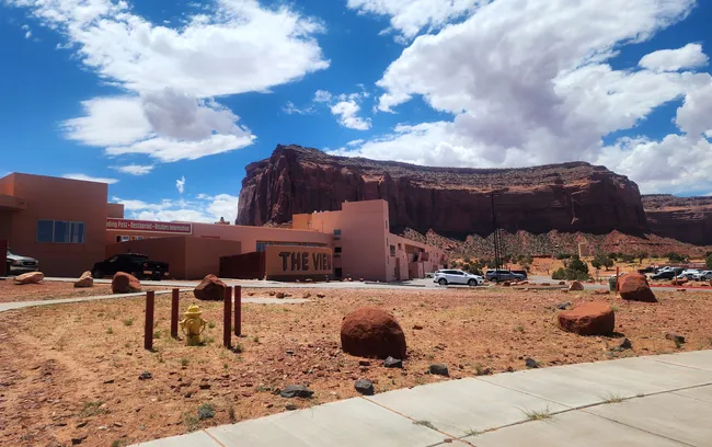 The View Hotel sits at the base of towering red cliffs in Monument Valley, with desert scenery all around.