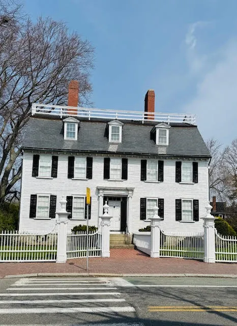 Colonial-style white Ropes Mansion with black shutters and white picket fence in Salem, Massachusetts.