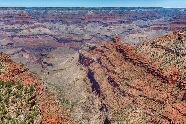 A sweeping view from Pipe Creek Vista showcases layered red rock cliffs and the rugged descent into the Grand Canyon.
