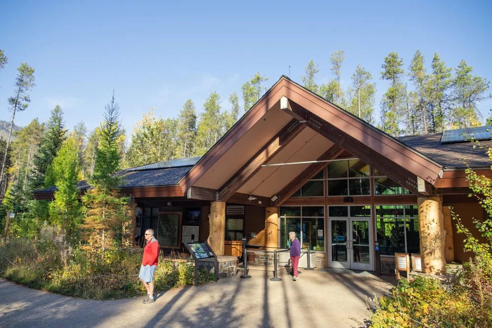 Visitor center surrounded by trees, designed to provide amenities like restrooms and information for families in national parks.