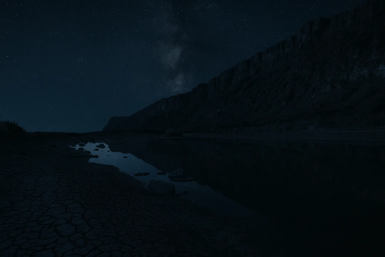 Starry night sky over Santa Elena Canyon in Big Bend National Park, with the canyon walls reflected in the still river below.
