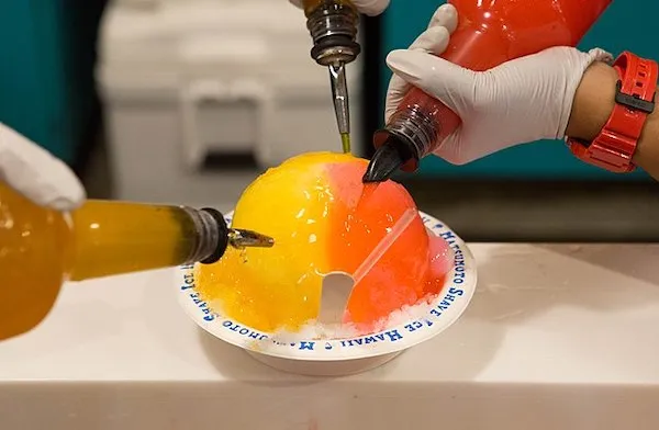 Shave ice being prepared with colorful syrups at Matsumoto's in Oahu.
