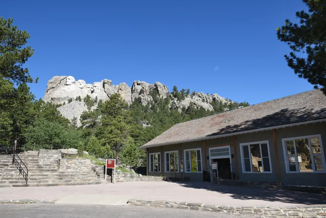 Visitor center and Sculptor’s Studio with Mount Rushmore carvings visible in the background.